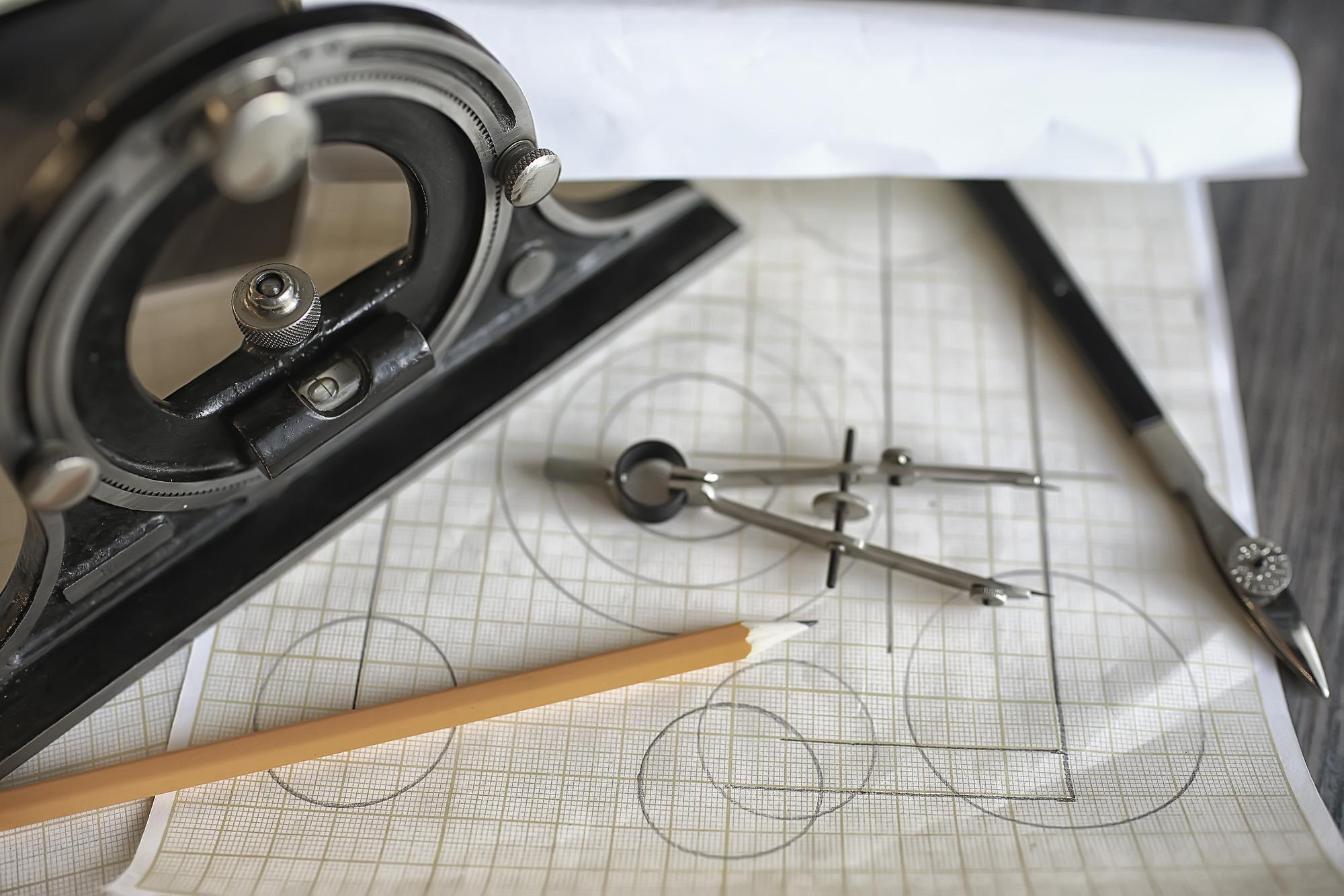 Werkbank mit Stickrahmen und technischen Skizzen